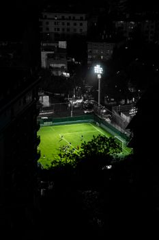 A captivating aerial shot of an illuminated soccer field in downtown Istanbul at night.