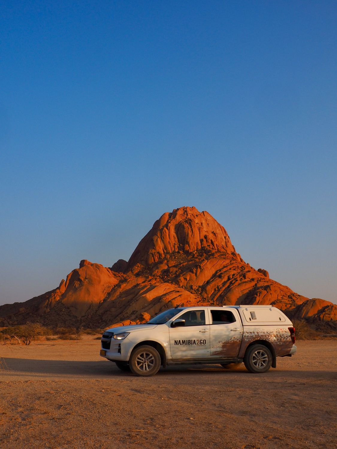 Photographer: Timon Cornelissen 4x4 vehicle with Spitzkoppe mountain in Namibia's desert landscape at sunset