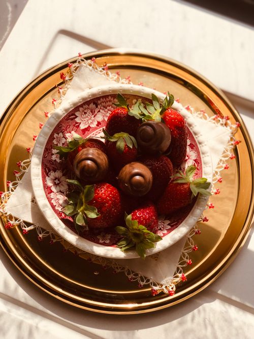 Free Elegant bowl of fresh strawberries and chocolates on decorative plates. Stock Photo