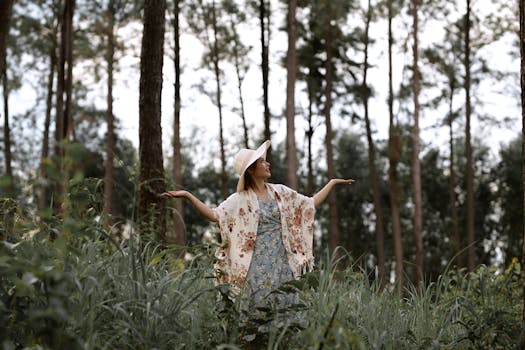 Woman in floral dress and hat exploring lush forest in Vietnam.