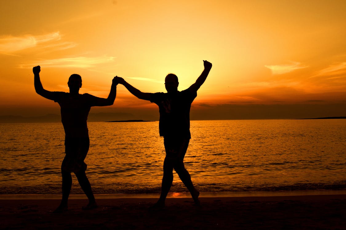 бесплатная Силуэт людей на пляже на закате Стоковое фото