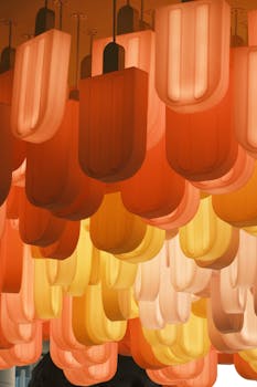 Artistic ceiling lights in vibrant colors resembling popsicles, creating a modern atmosphere.