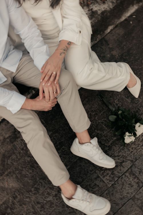 Free Close-up of a couple holding hands seated outdoors, symbolizing love and togetherness. Stock Photo