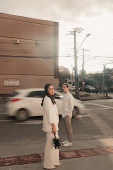 A couple crosses a city street at dusk, highlighting urban lifestyle and motion.