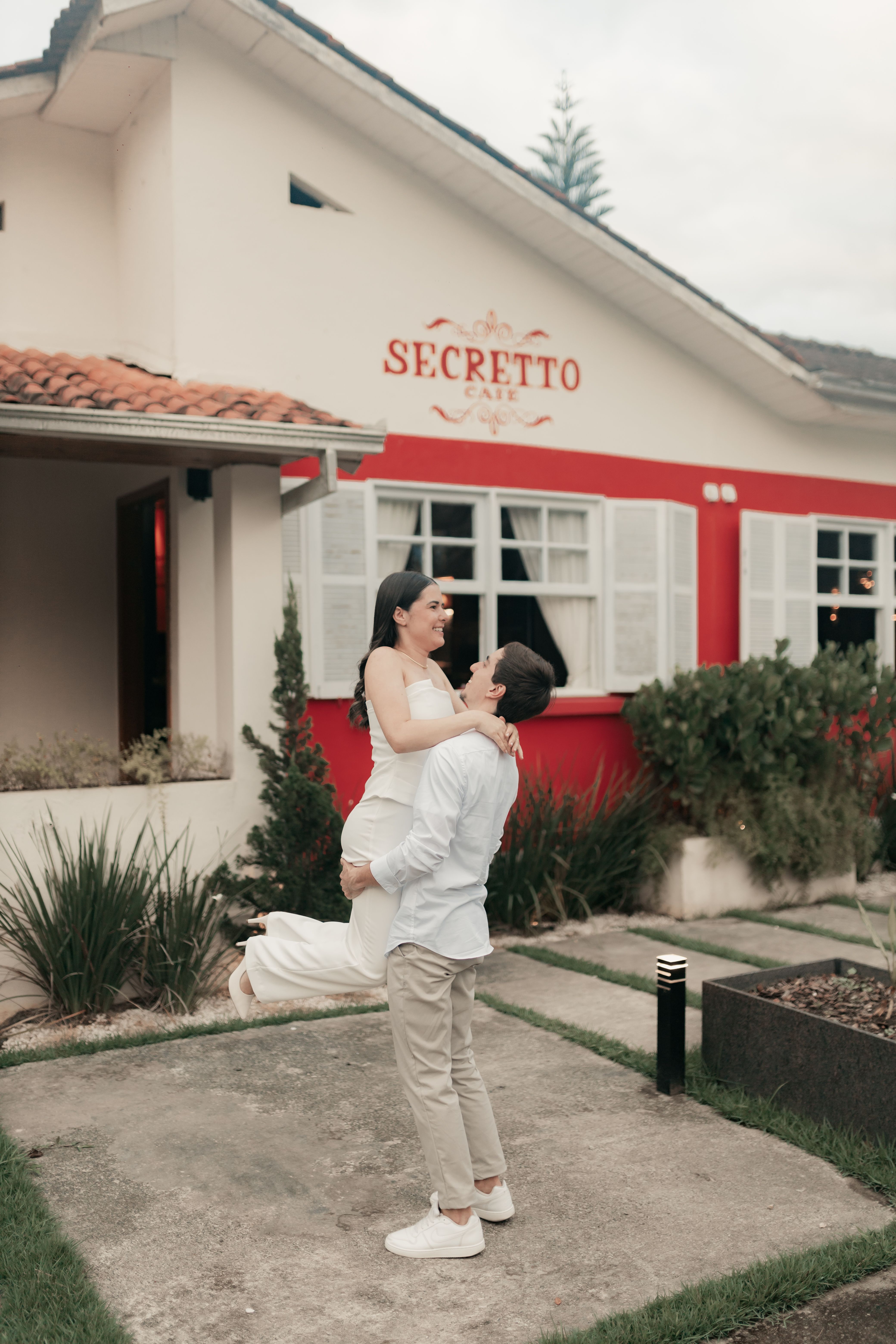 Couple sharing a romantic moment outside the charming Secreto Cafe.
