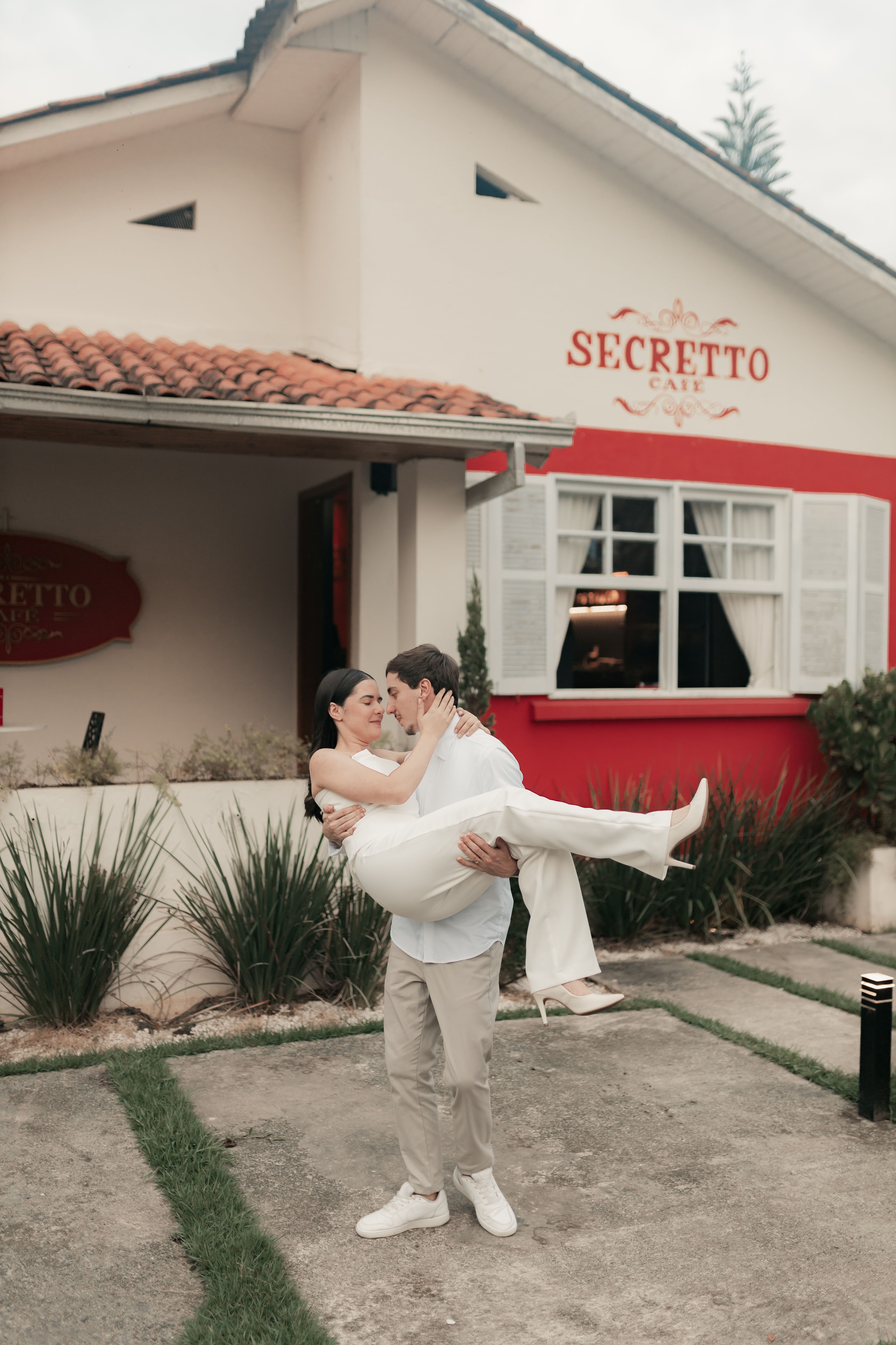 A man lifts a woman in a loving embrace outside Secreto Cafe.