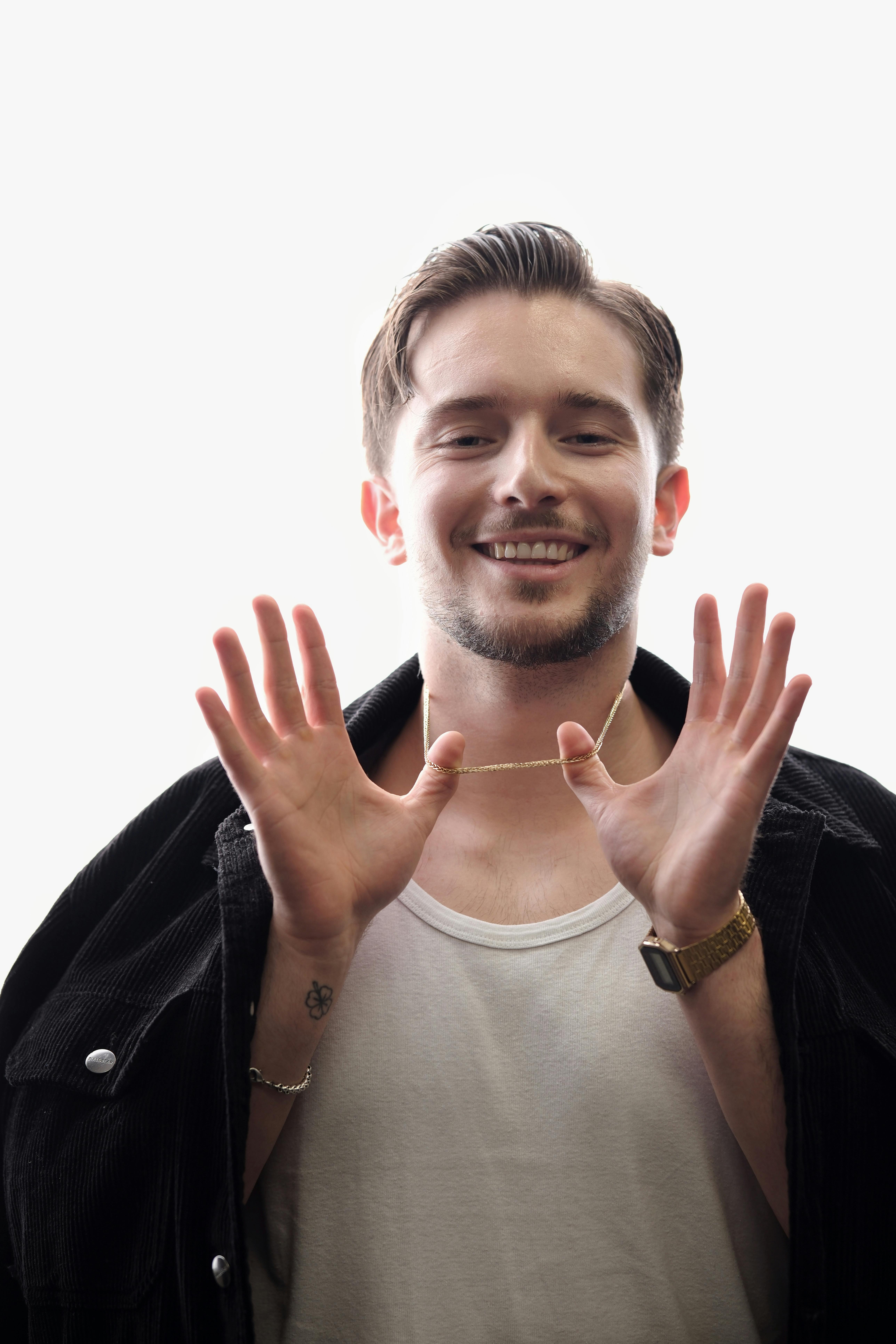 Miễn phí Chàng trai trẻ mỉm cười trong trang phục thường ngày tạo dáng với thái độ thoải mái. Ảnh lưu trữ