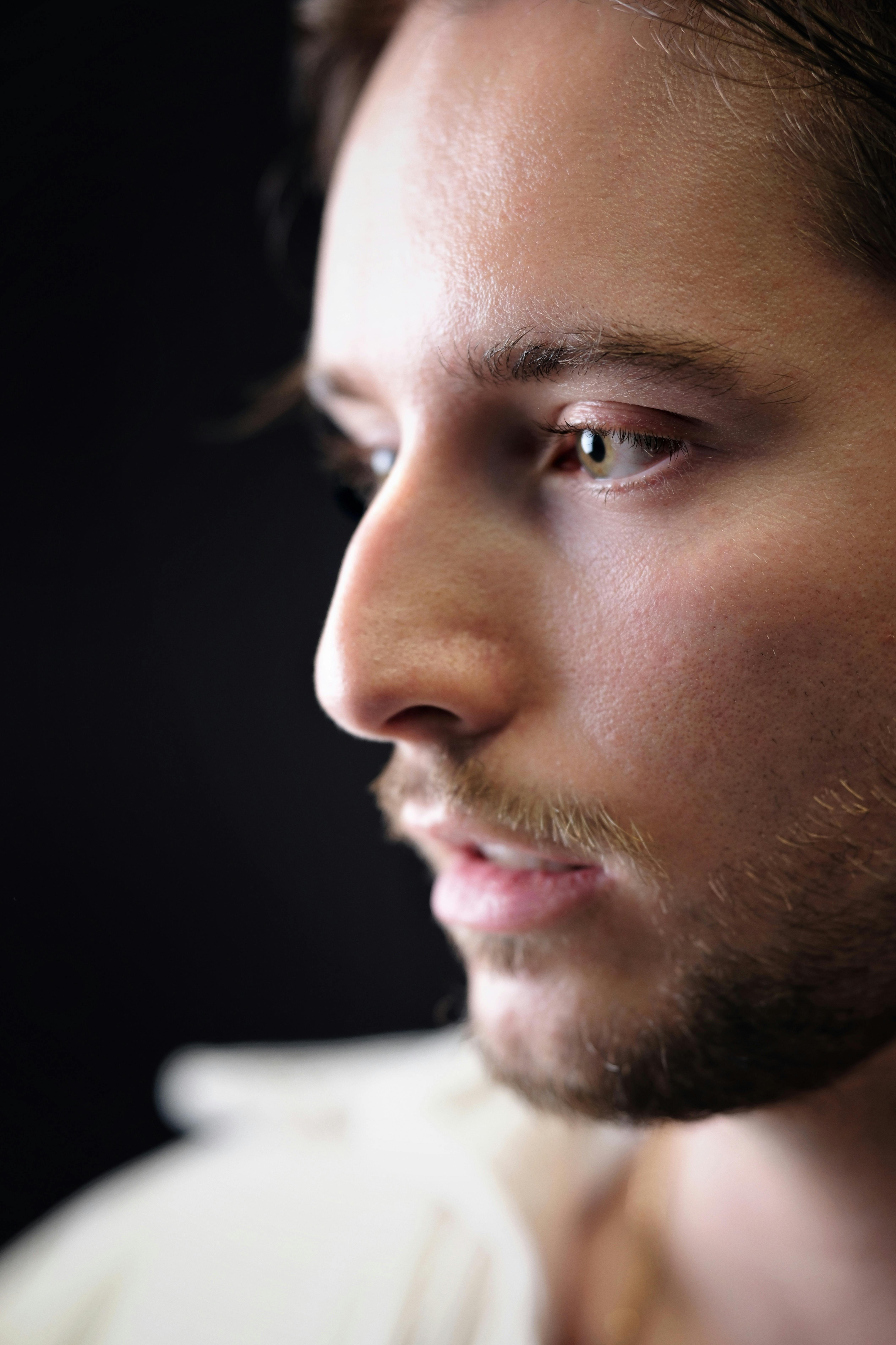 Detailed close-up of a young man in deep thought, highlighting facial features.