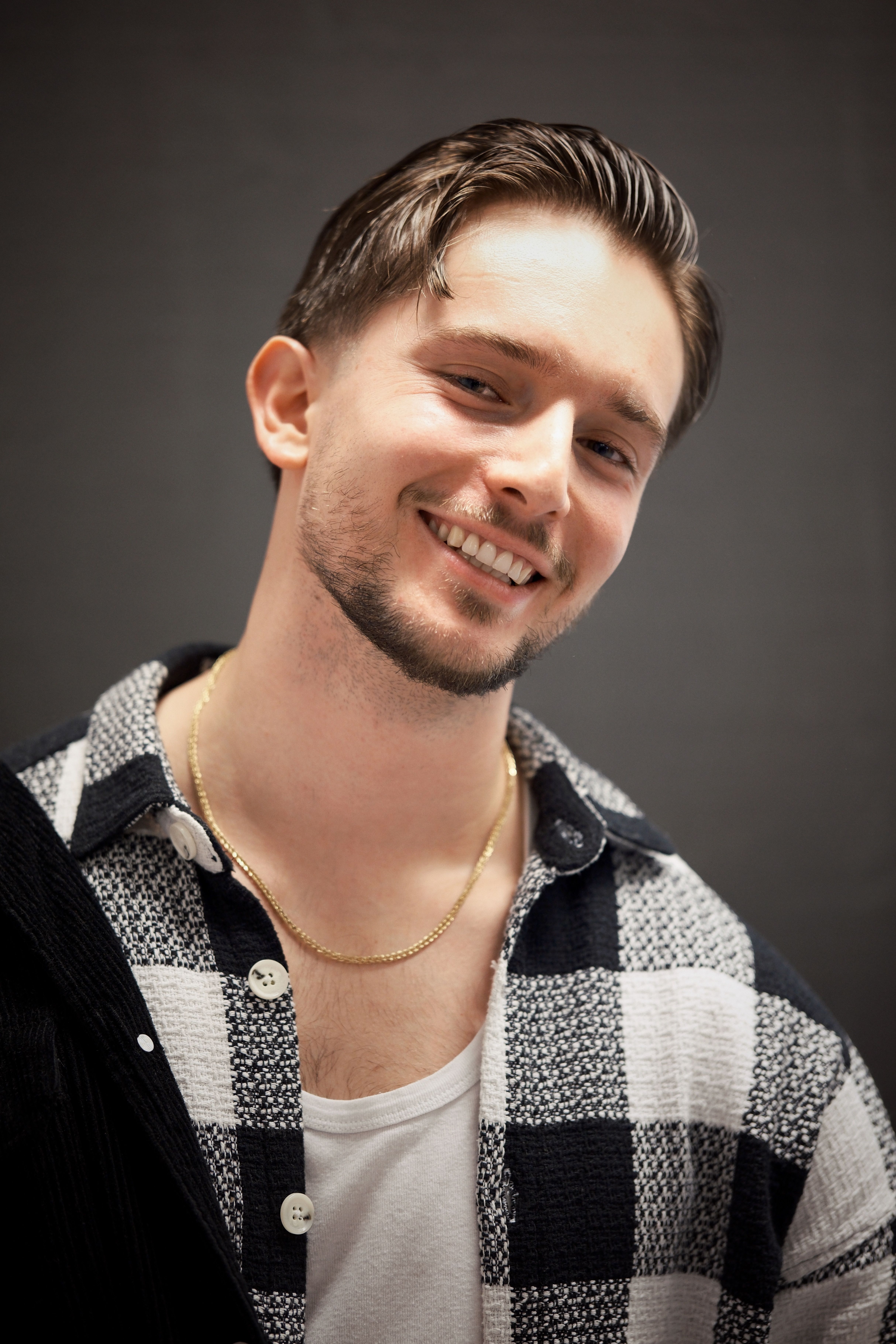 Smiling Young Man in Checkered Shirt Portrait · Free Stock Photo — free download