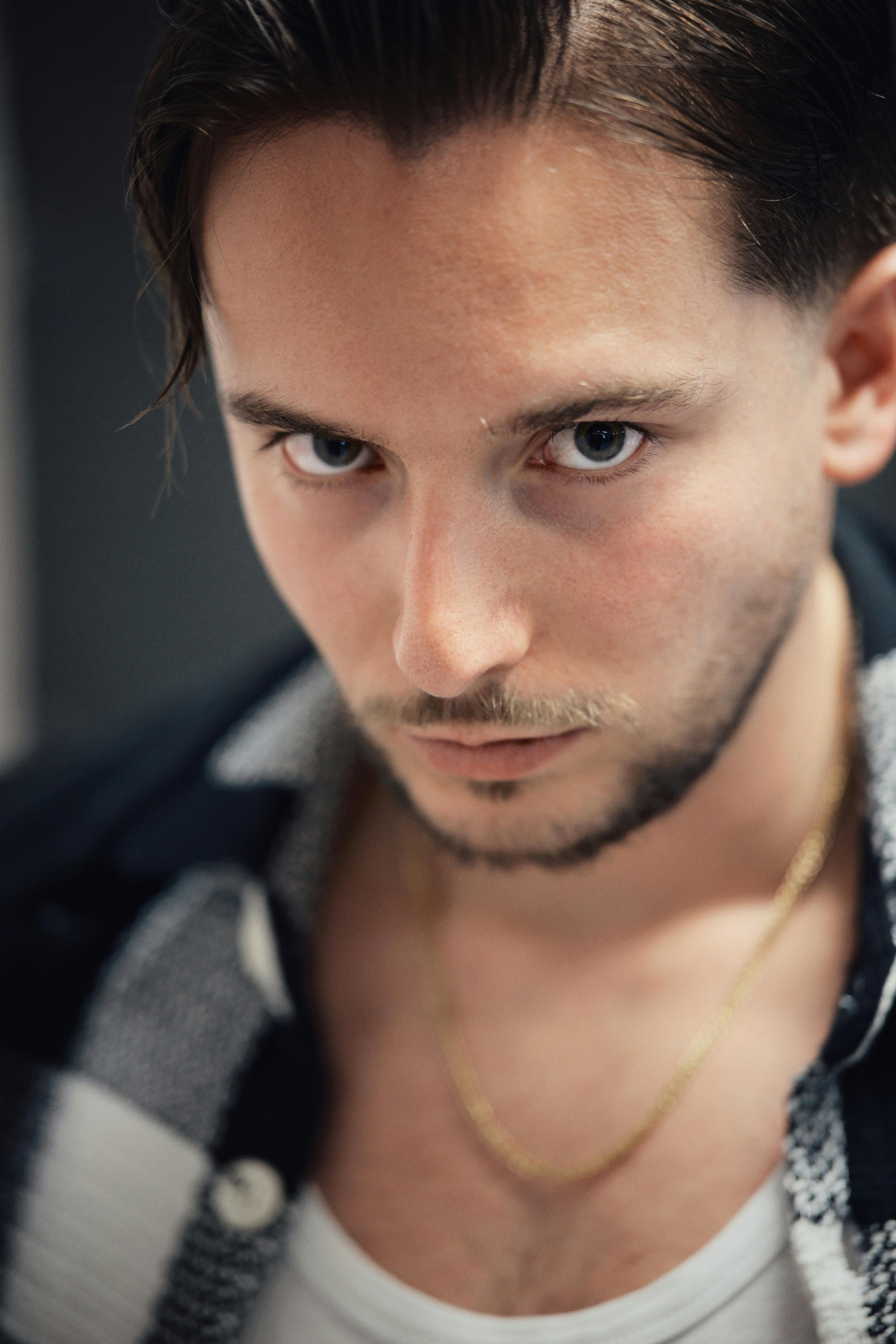 Portrait of a young man with intense gaze, wearing casual stylish attire. Perfect for fashion or lifestyle themes.