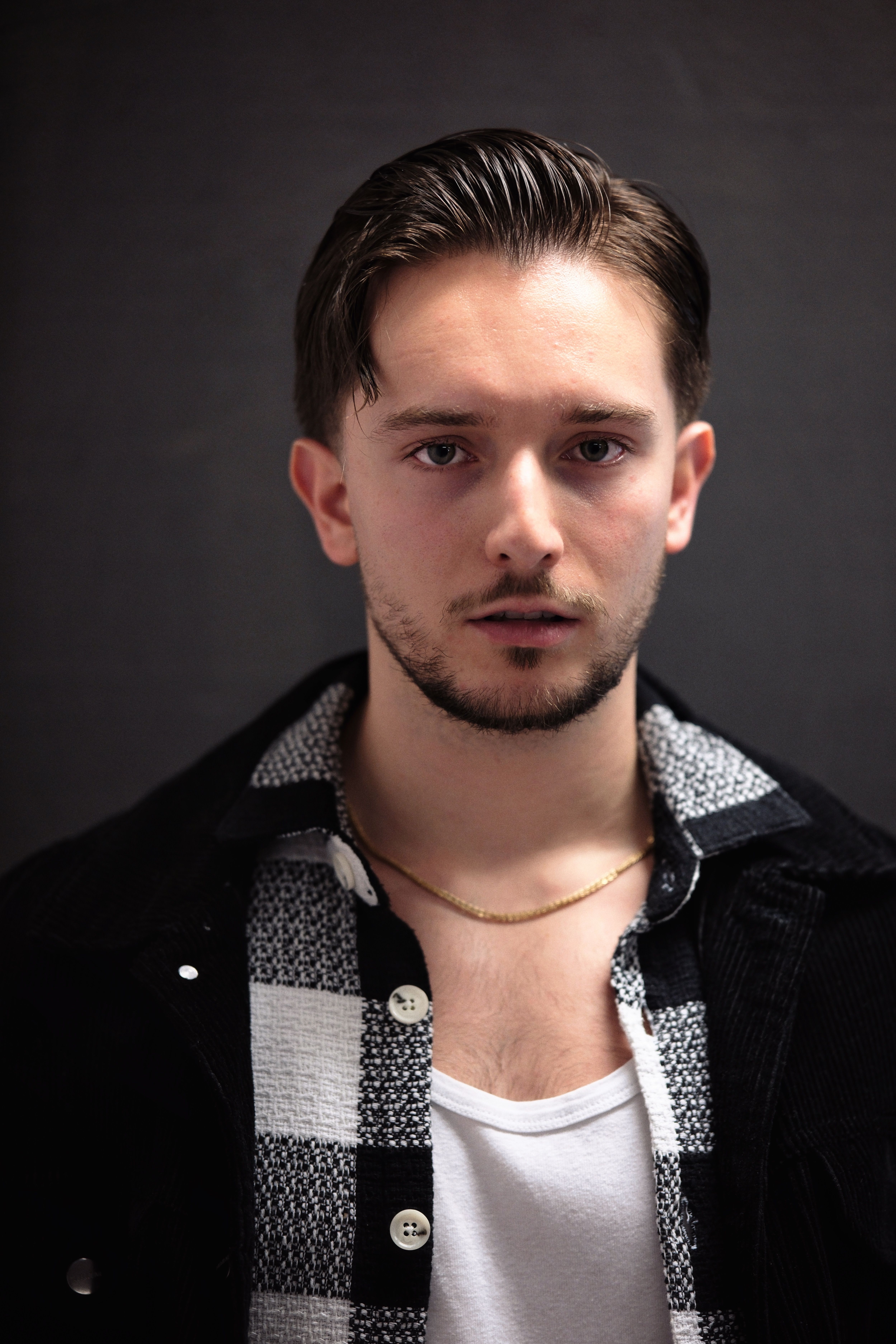 Gratis Ritratto ravvicinato di un giovane con acconciatura moderna e vestiti alla moda. Foto a disposizione