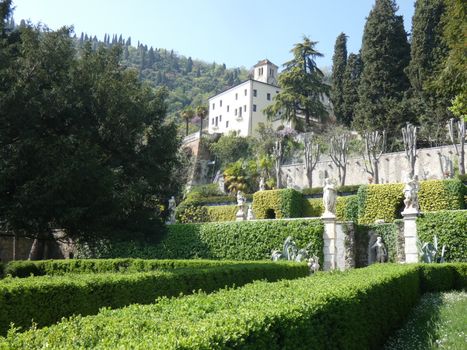 Lush villa gardens with statues and greenery in Costozza, Veneto, Italy.