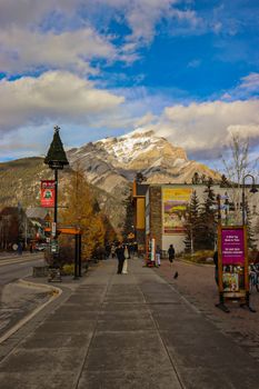 Street view of Banff, Canada with impressive mountain backdrop under a blue sky.