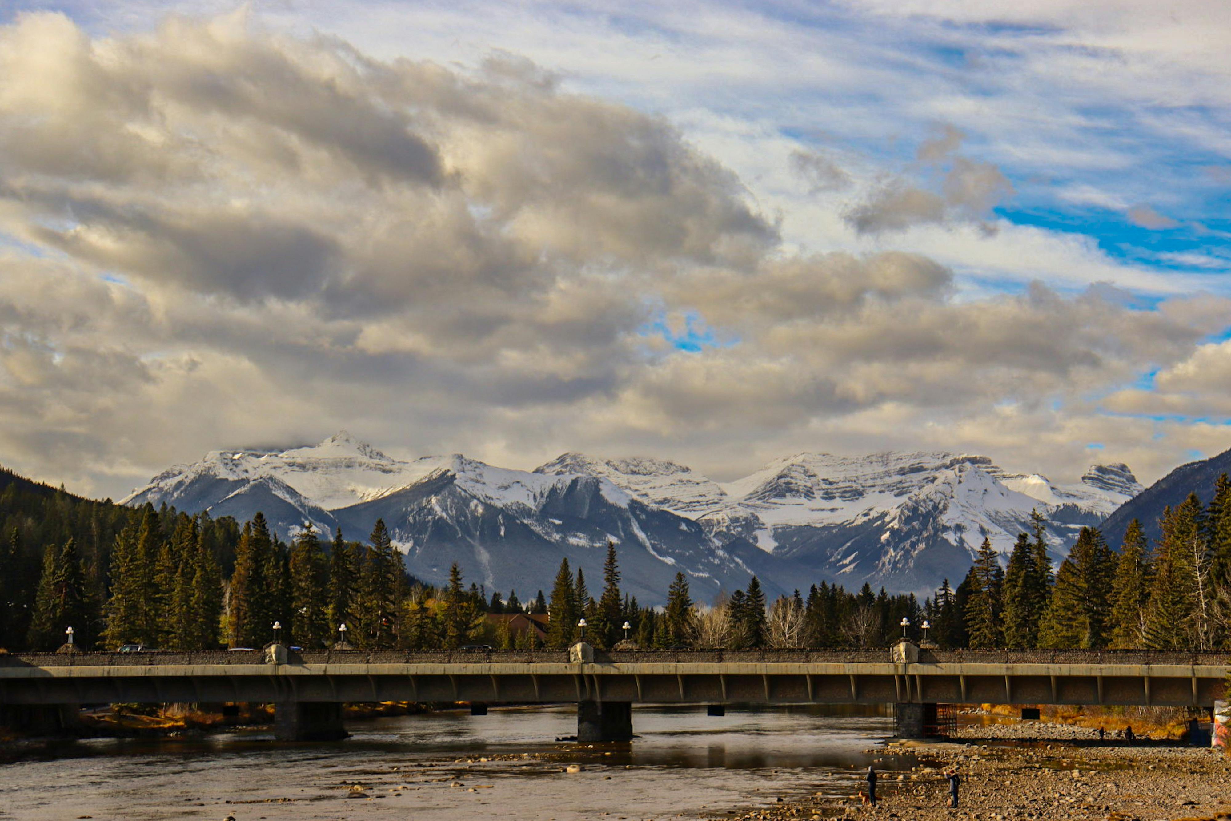 Stunning view of snow-capped mountains in Banff National Park, Alberta, Canada with a bridge in the foreground. - Banff