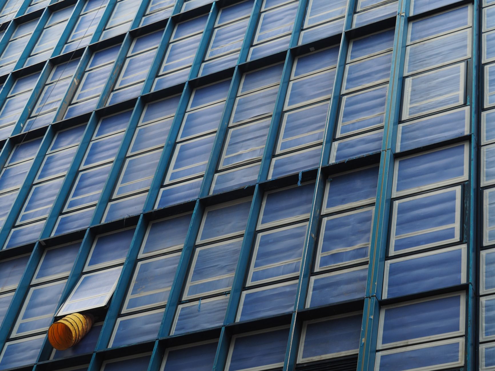 玻璃隔熱7種做法比較表:效果難易美觀一次看 Detailed photo of a modern glass facade in Hong Kong showcasing repetitive window patterns.