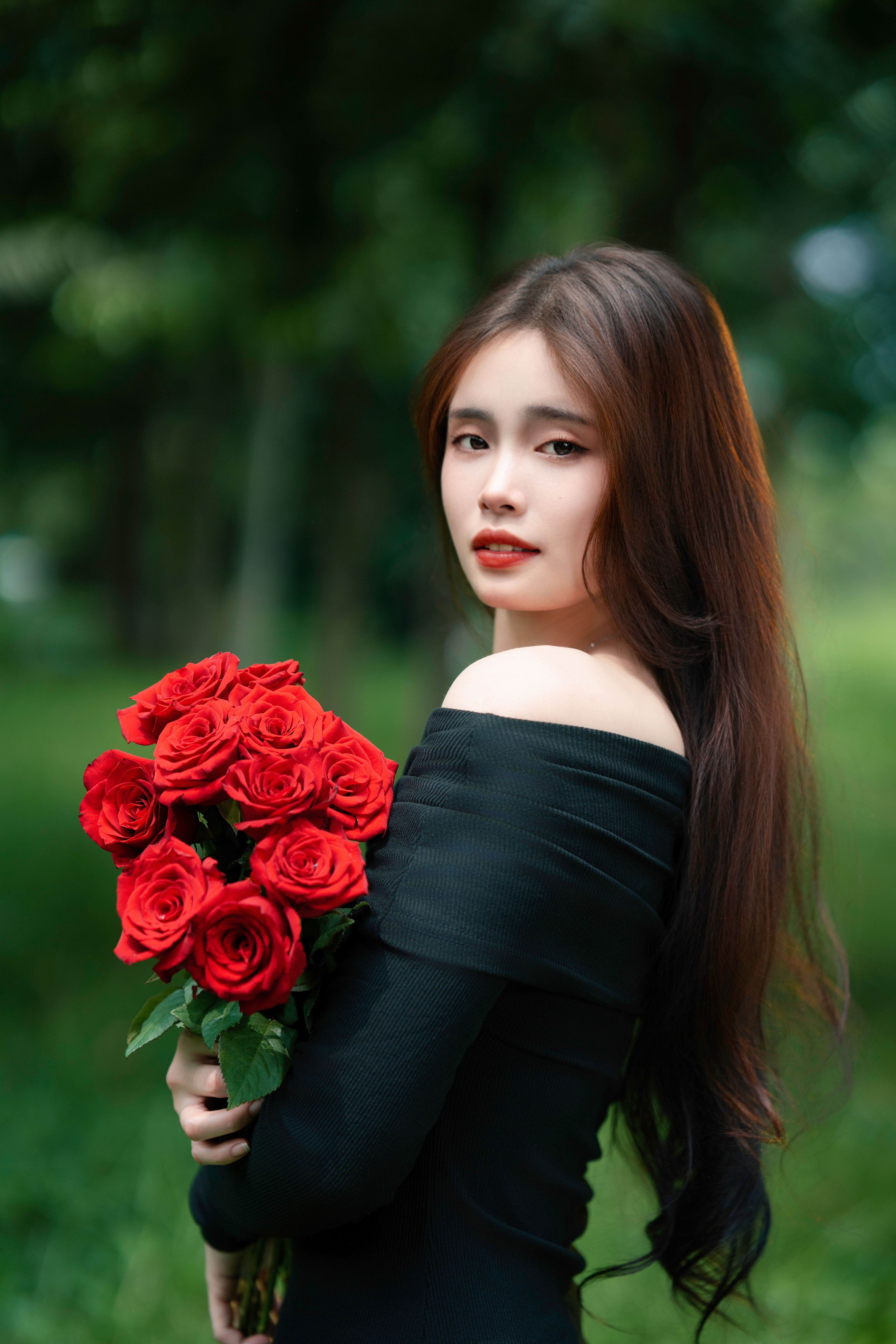 Elegant Woman Holding Red Roses in Nature · Free Stock Photo