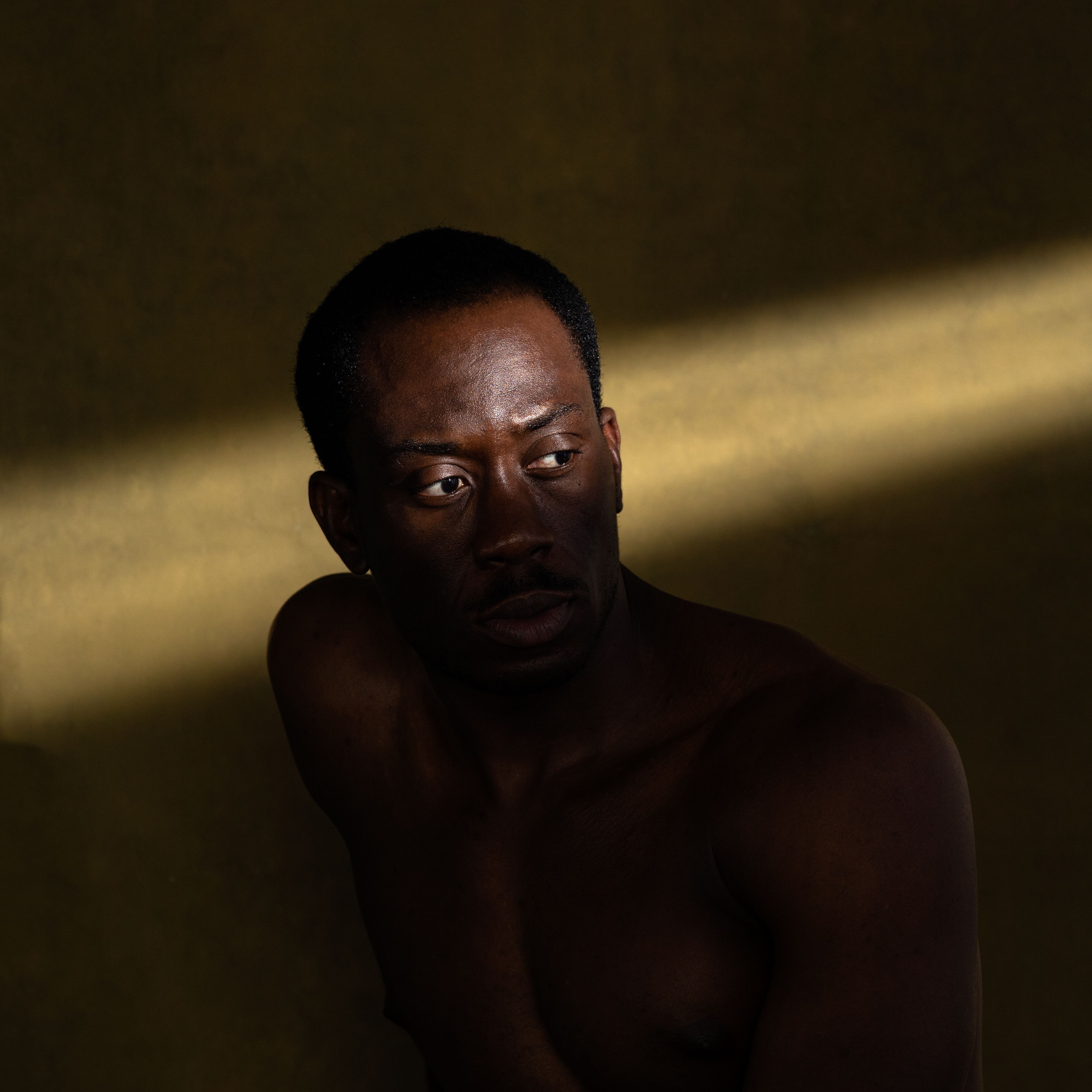 Striking portrait of a man in moody, dramatic lighting; ideal for expressive art and editorial use.