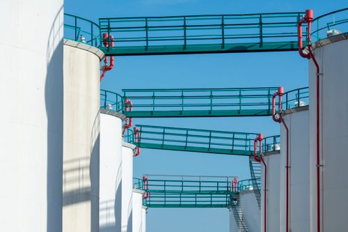 Free Modern industrial storage tanks with walkways against a clear blue sky. Stock Photo