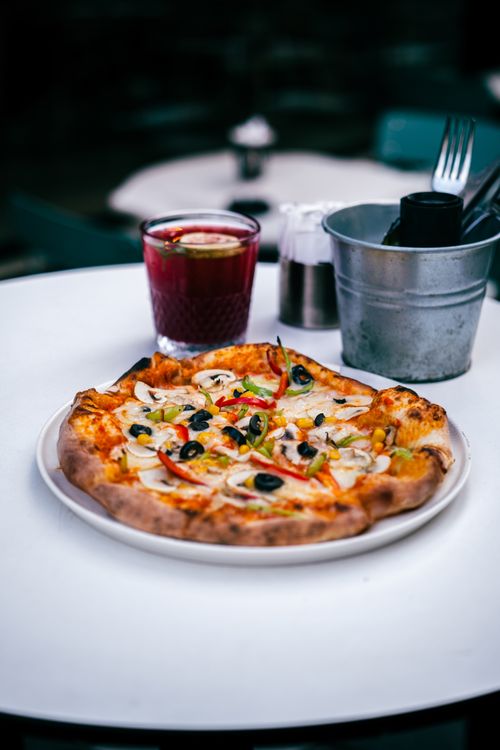 Free A vibrant photo of a homemade pizza with fresh toppings served alongside a drink, perfect for food enthusiasts. Stock Photo