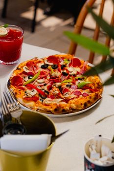A vibrant, freshly baked pepperoni pizza with various toppings served on a restaurant table.