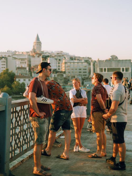 Free Group of young adults enjoying a sunny day on a Istanbul bridge with Galata Tower view. Stock Photo