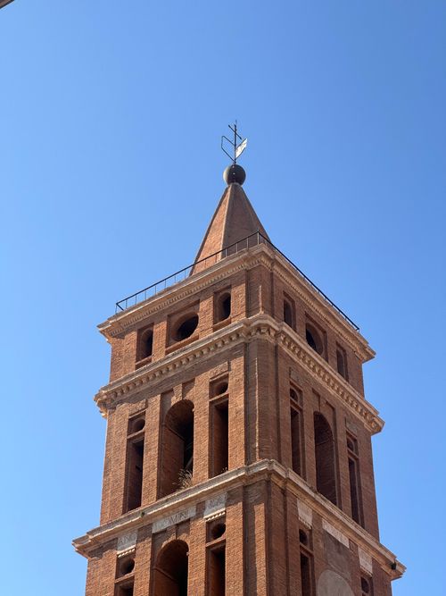 Free Explore the architectural beauty of a historic bell tower in Tivoli, Italy against a clear blue sky. Stock Photo