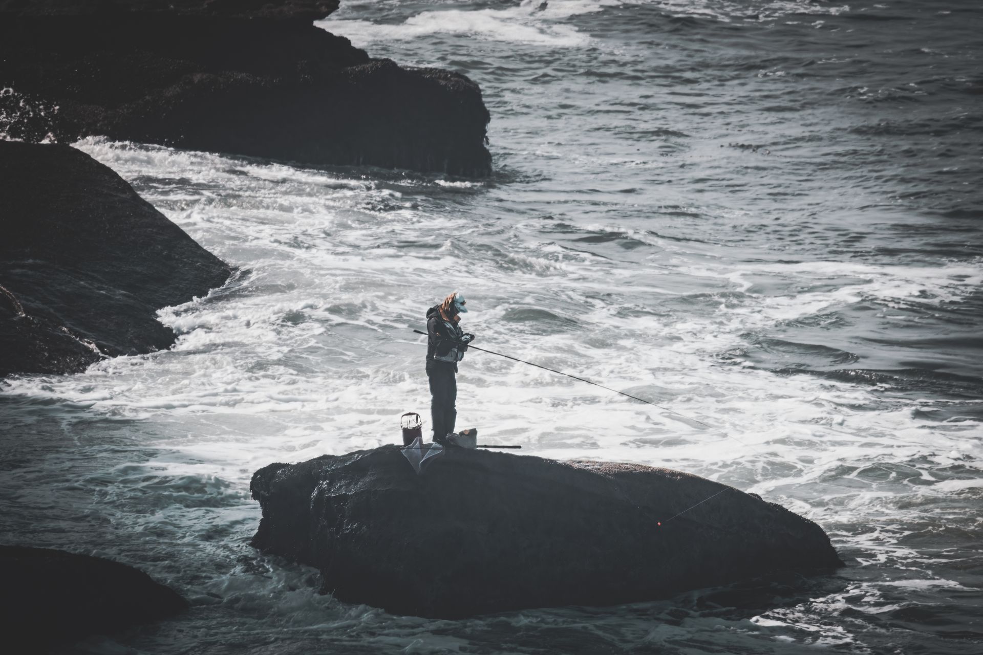 Fisherman casting on rocky Wild Coast shoreline at sunrise
