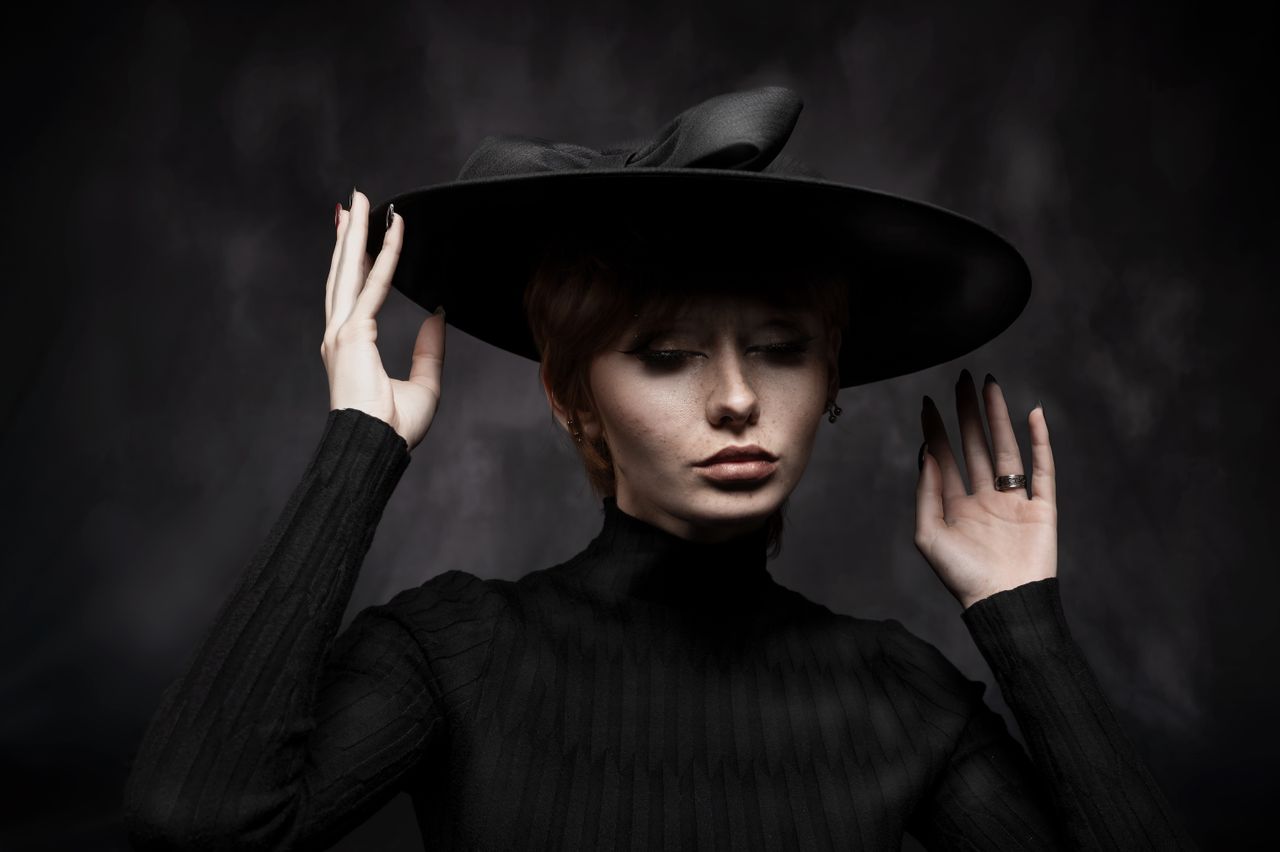 stylish portrait of a woman wearing a wide brimmed black hat exuding e