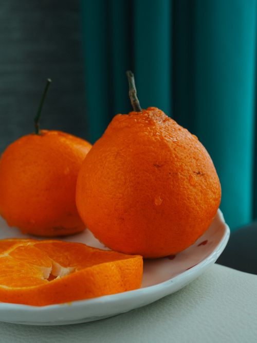 Free Vivid oranges on a plate create a minimalistic and vibrant scene. Stock Photo