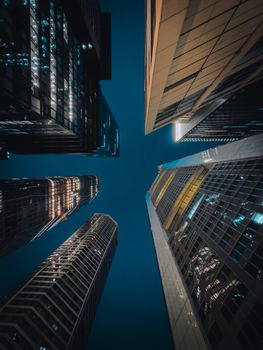 Upward view of illuminated skyscrapers at night in Frankfurt, Germany.