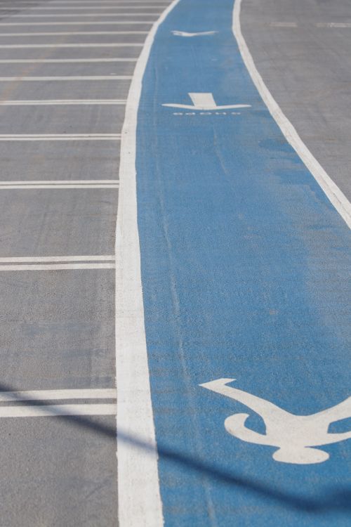 Free Urban bike lane with blue paint markings on asphalt road. Ideal for urban planning visuals. Stock Photo