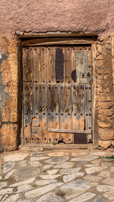 Fotomural Una puerta de madera rústica con marco de piedra, que irradia encanto vintage.