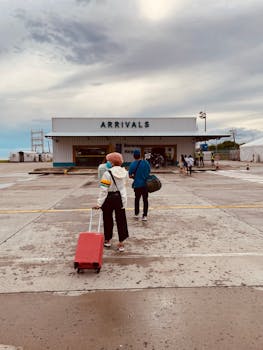 People arriving at Malay Airport under a cloudy sky, capturing travel and arrival themes.