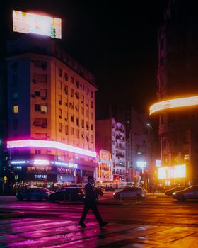 Vibrant city nightlife with neon lights illuminating a bustling street scene.