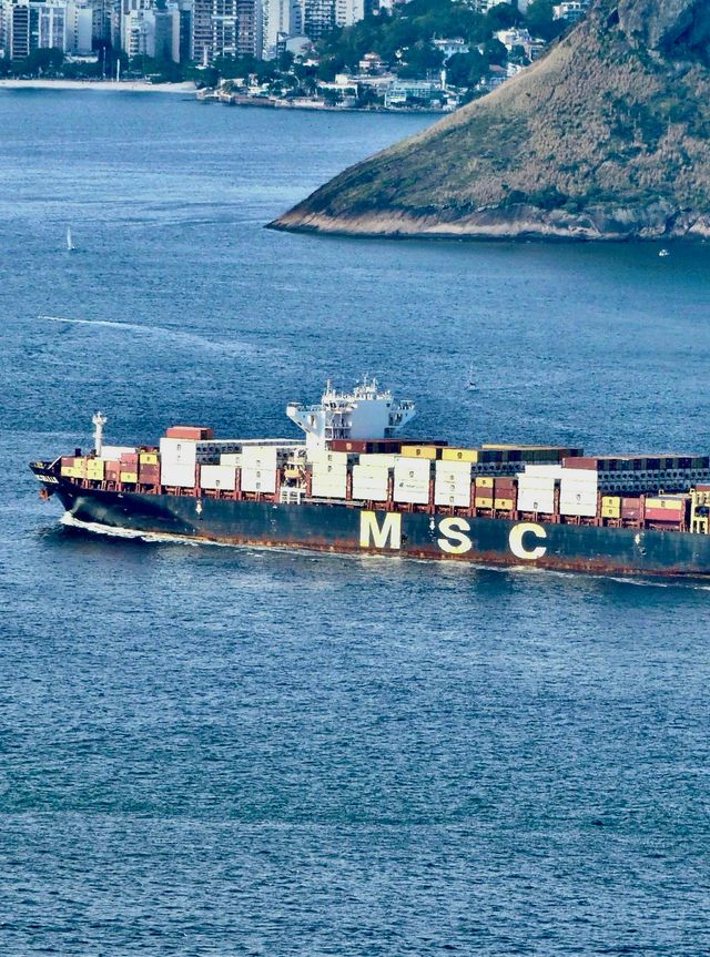 Aerial view of a massive cargo ship near a coastal city