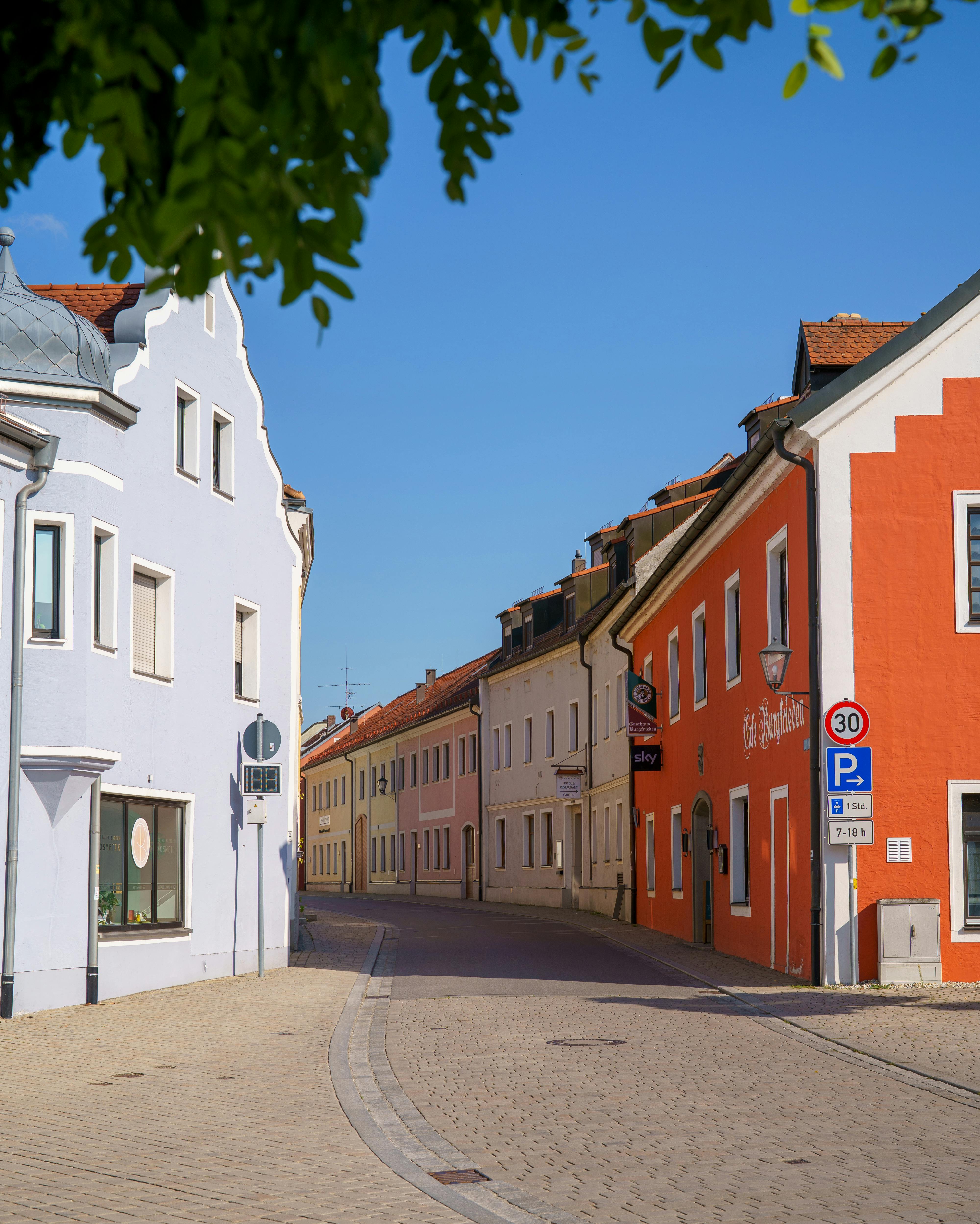 Charming European street scene featuring colorful historic buildings and a clear blue sky.