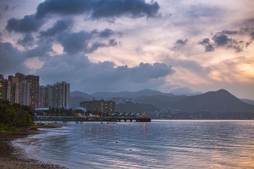 Free Captivating twilight view of Hong Kong waterfront, highlighting urban skyline and mountains. Stock Photo