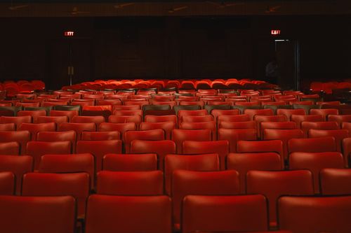 Free Rows of empty red seats inside a classic movie theater with a vintage ambiance. Stock Photo
