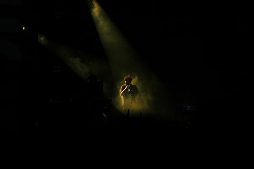 Captivating concert scene featuring a flute player under dramatic stage lighting.