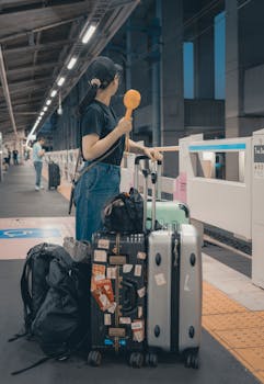 A traveler with suitcases waits at a Tokyo train station, ready for adventure.