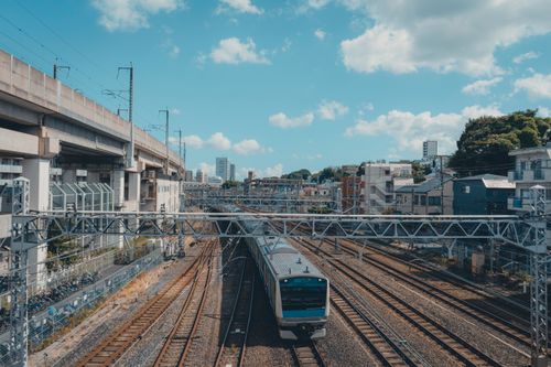 Free A train traversing elevated tracks in Tokyo's urban landscape, showcasing modern infrastructure. Stock Photo