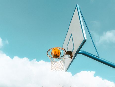 A basketball hoop and ball with a bright sky in Kenitra, Morocco.