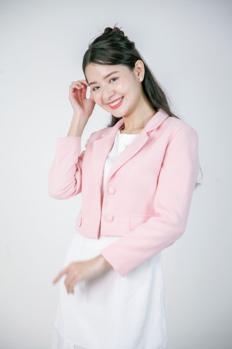 Woman in a pink blazer and white dress