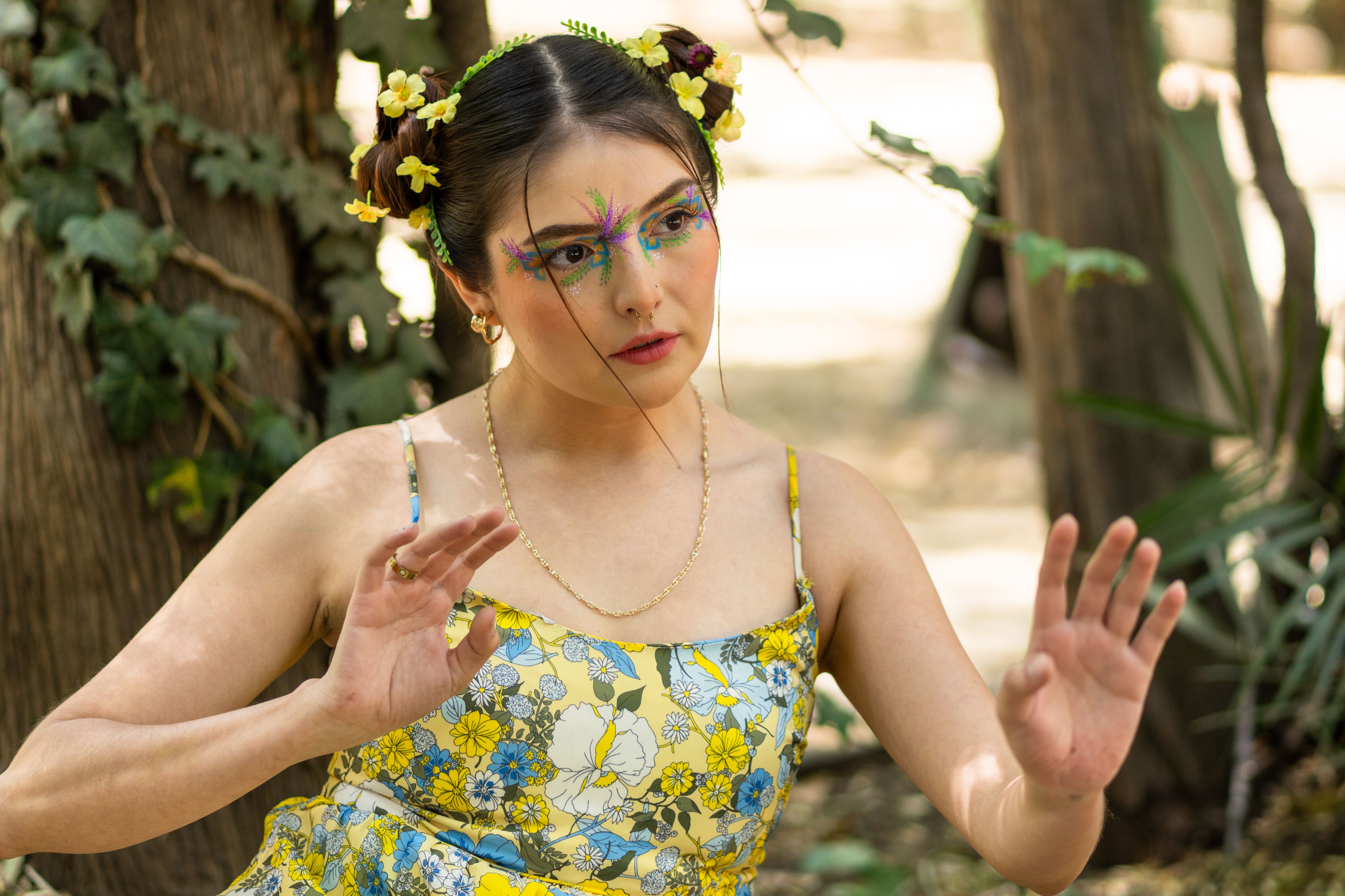 芸術的なメイクと花柄のドレスを着た屋外の女性の鮮やかなポートレート。