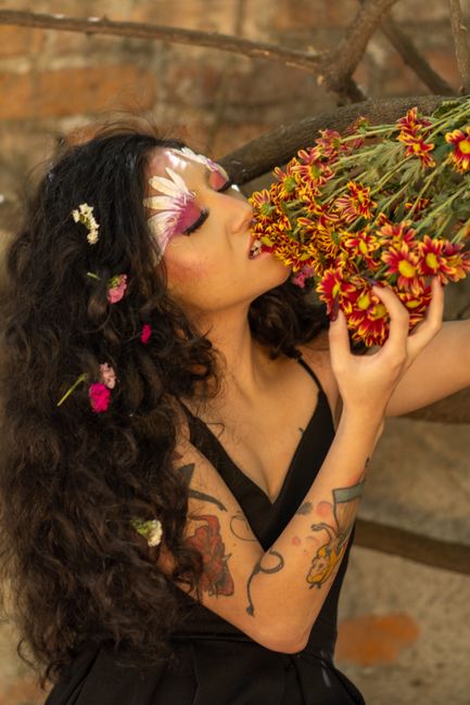 Fotomural Un retrato artístico vibrante de una mujer con maquillaje floral y un ramo de flores, capturado en Ciudad de México.
