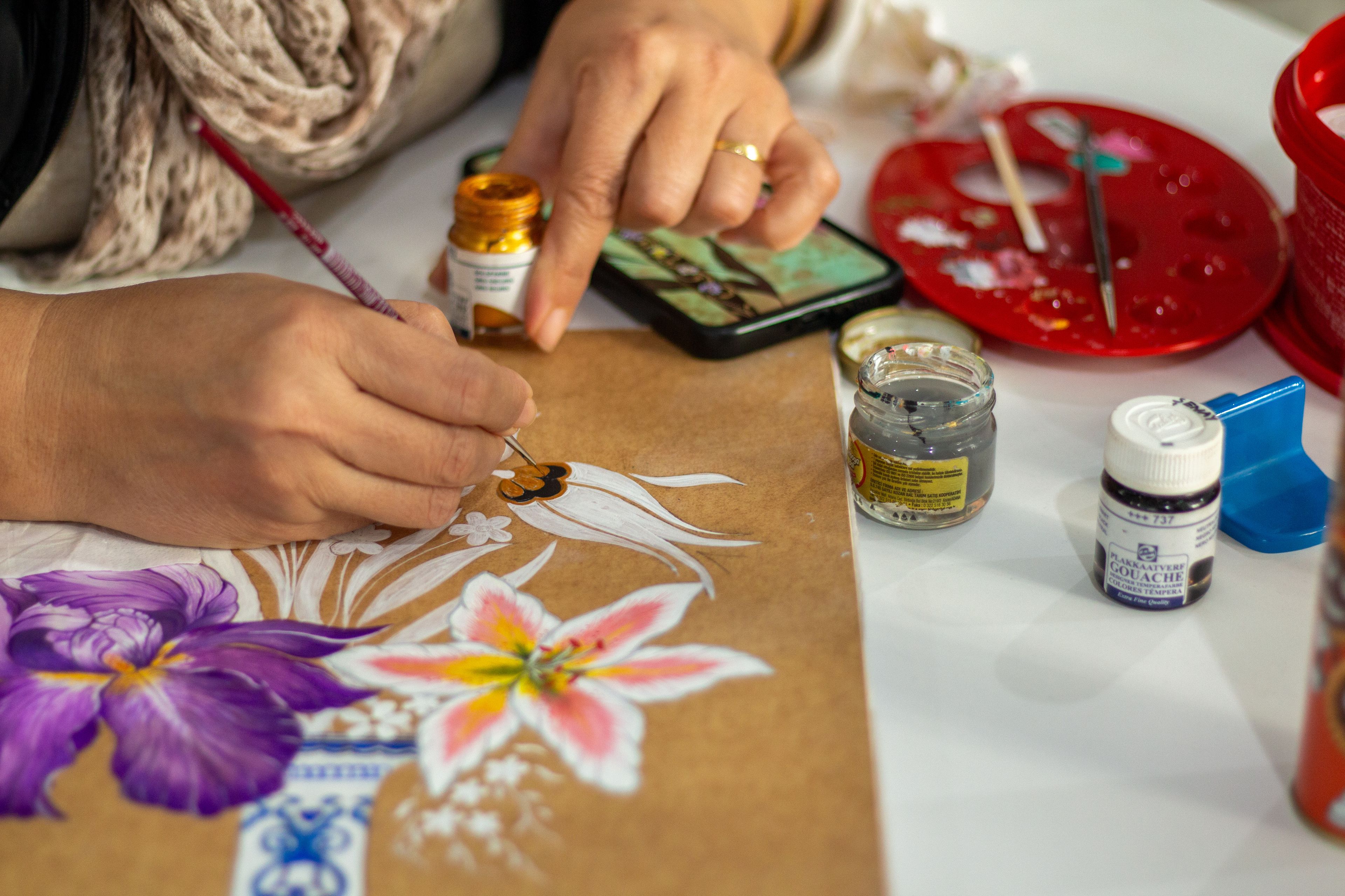 Painting lilies in gouache, brush mid-stroke