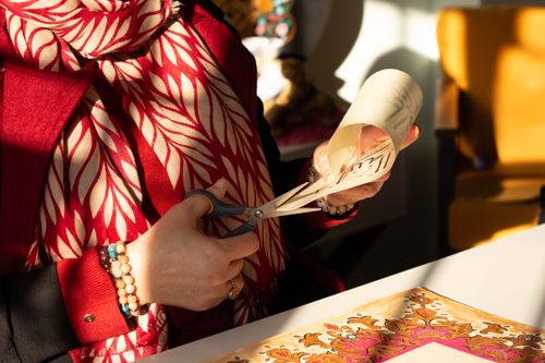 Free Close-up of a woman using scissors to craft paper in warm daylight. Stock Photo