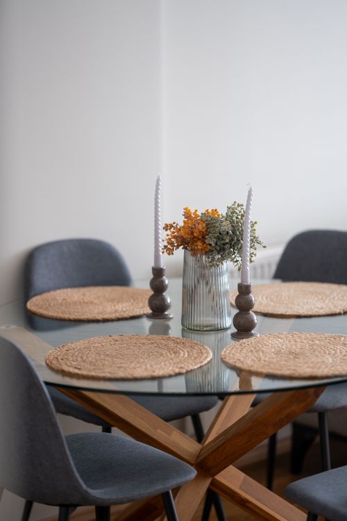 Free Bright, minimalist dining room with Scandinavian design featuring woven placemats and modern chairs. Stock Photo