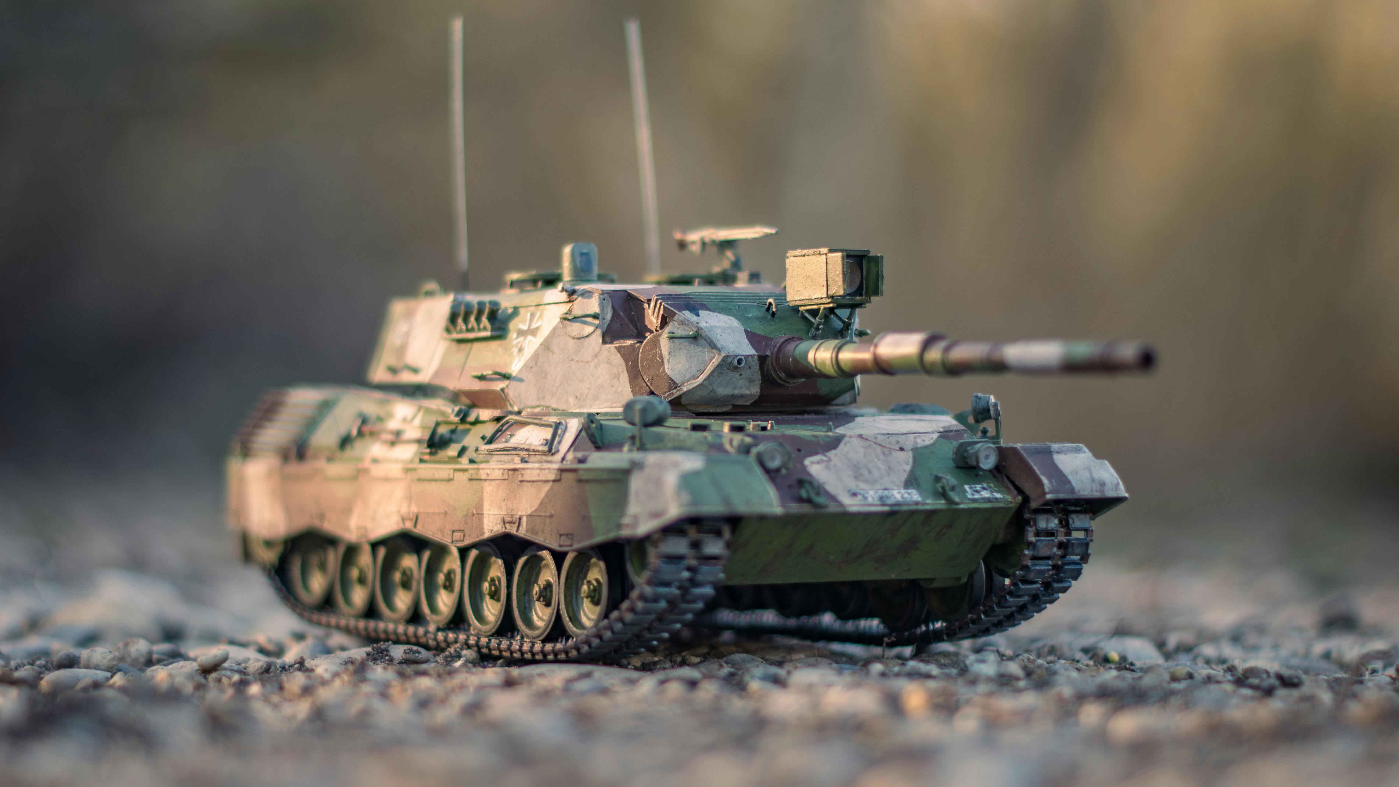 Ücretsiz Açık havada çakıllı yolda kamuflajlı askeri tank modelinin detaylı görünümü. Stok Fotoğraflar