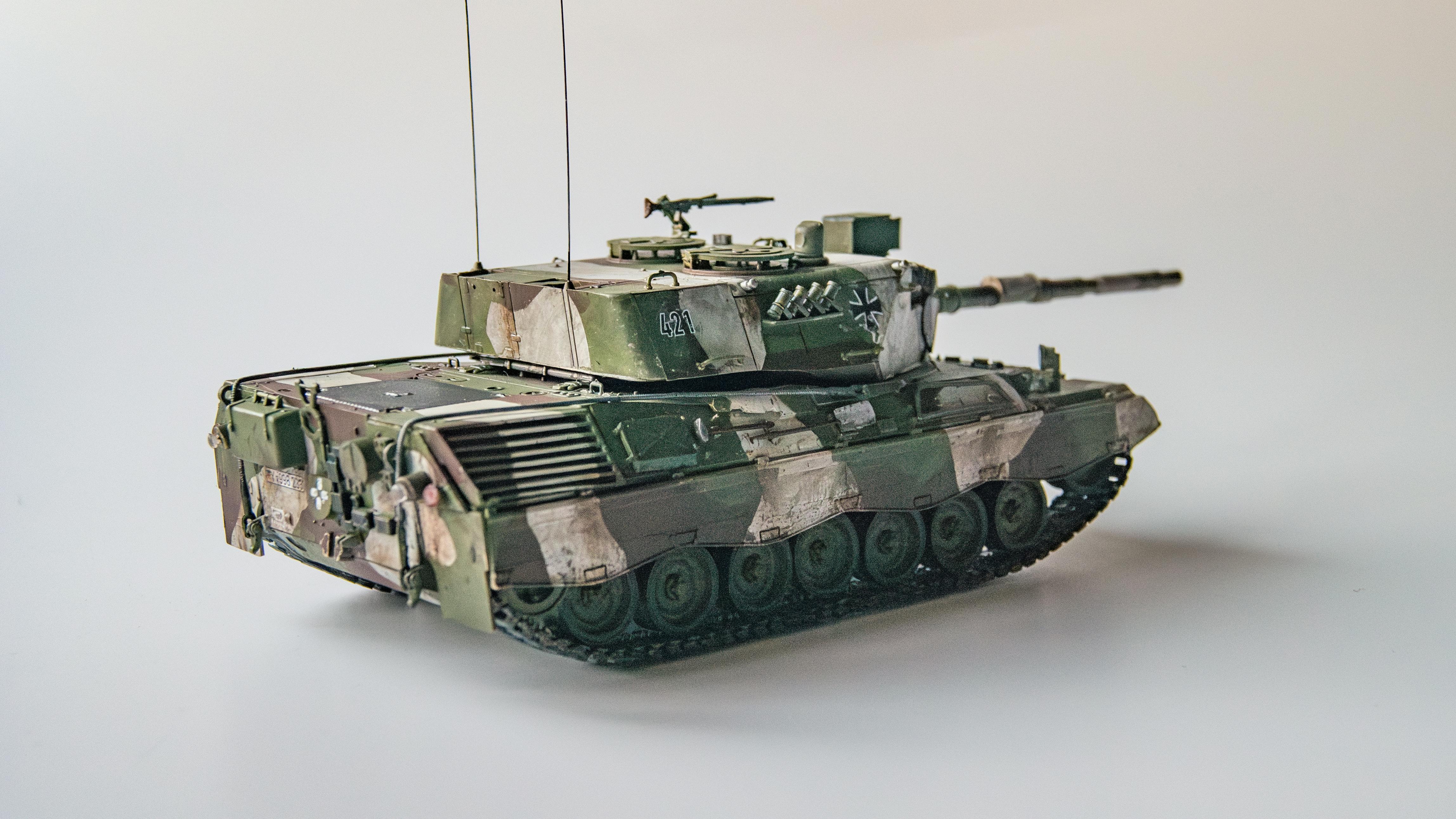 bezplatná Detailně zpracovaný model tanku Leopard 2 s kamufláží a vojenskými znaky. Základová fotografie